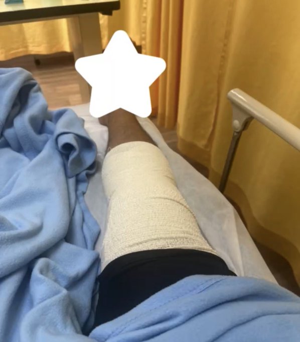 The image shows a person lying down with their leg propped up, wearing a cast or brace for support. They are resting on a bed covered with blue sheets. The caption of the image reads "I arrived safely in my city now I will not go into details #Binance I am not sure Binance would want me to share them publicly sorry @cz_binance @heyib finance But I want to say thank you The Binance team showed me so much care today and kept checking on me until I arrived".