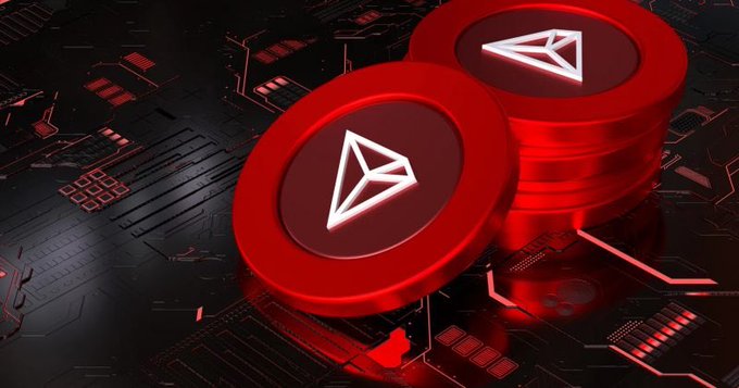 Two glowing red TRON (TRX) cryptocurrency coins stacked on a dark, futuristic circuit-board background.