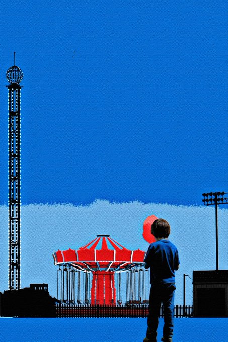 The image features a young boy standing next to an amusement park ride, holding onto a balloon. The background of the photo shows a blue sky with clouds, creating a sense of depth and atmosphere. There are also other people visible in the scene, possibly enjoying their time at the amusement park as well.