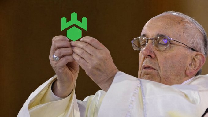 Pope Francis, wearing white robes and glasses, holds up a green logo resembling the NEO cryptocurrency symbol.