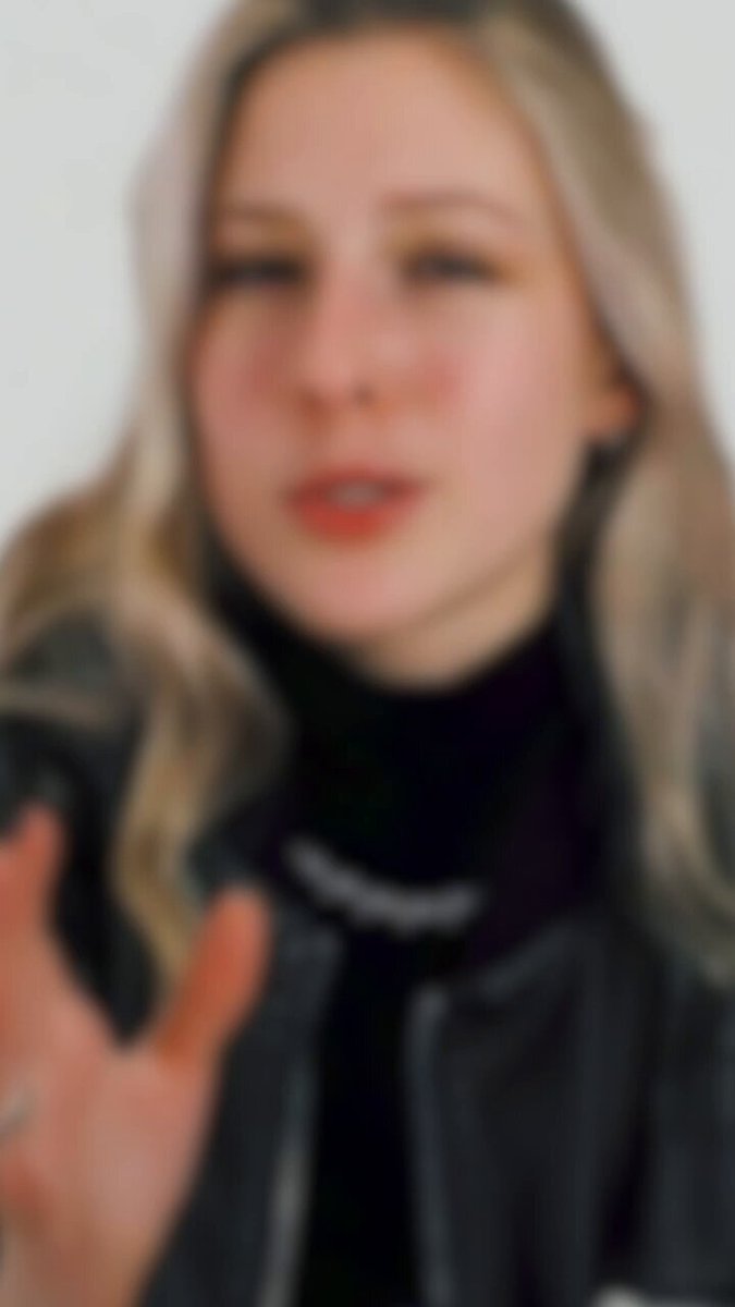 The image features a woman with blonde hair wearing a black jacket, standing against a white background. She has her hand outstretched towards the camera, making direct eye contact with the viewer. The caption below the photo reads "Here @pauli_speaks breaks down what makes REAL different." This suggests that the image is related to a discussion or analysis of real estate technology and its impact on the industry.