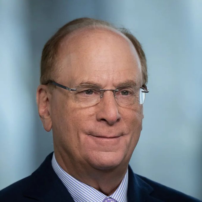 A close-up portrait shows a balding older man wearing rimless glasses, a dark suit jacket, and a blue striped shirt, set against a soft blue gradient background—likely a professional headshot of a financial executive or commentator discussing BlackRock's recent $54.8M Bitcoin purchase and the ongoing demand for spot Bitcoin ETFs.