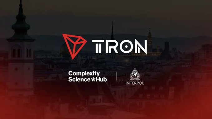 The image features a darkened cityscape backdrop overlaid with the TRON logo, the "Complexity Science Hub" label, and the INTERPOL emblem, visually representing TRON DAO's participation alongside INTERPOL and academic institutions at the 5th INTERPOL New Technologies Forum held September 29–30 to address blockchain and emerging technology security challenges.