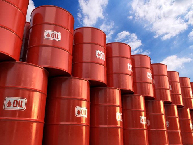 Rows of red oil barrels labeled "OIL" stacked against a partly cloudy sky, symbolizing the energy markets and commodity volatility referenced in the post about liquidity-driven price action.