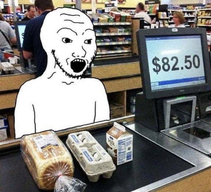 A Wojak meme character with an exaggerated shocked expression stands at a grocery checkout with bread, eggs, and a milk carton on the conveyor belt, while the register displays $82.50.