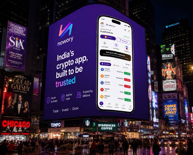 An advertisement for 'nowory' displayed on a large Times Square billboard, describing it as 'India's crypto app, built to be trusted' and showing a mobile interface.
