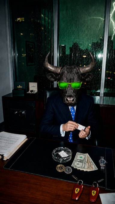 A suited figure wearing a bull mask and green sunglasses sits at an office desk holding cash, with dollar bills, coins, a lighter, and Ferrari key fobs scattered in front of a rainy window—matching the "bull is in office" market mood post.