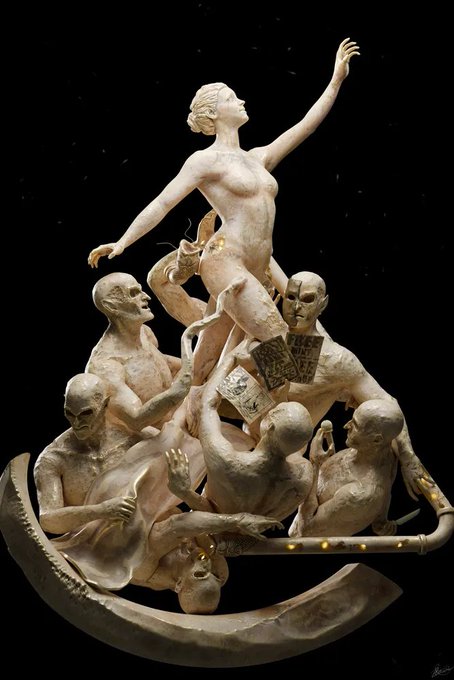 A dramatic sculpture depicting a nude woman with raised arms standing in a boat filled with bald male figures, one of whom holds playing cards.