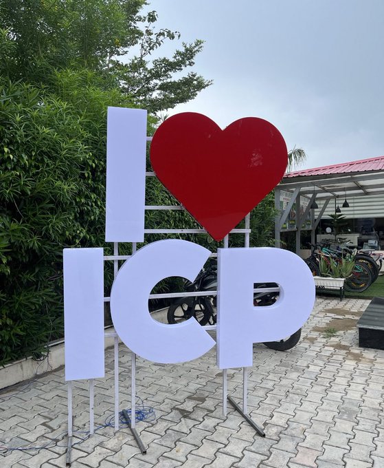 A "I ❤️ ICP" sign stands prominently at what appears to be a motorcycle showroom, reinforcing the post's theme of unwavering dedication to the ICP ecosystem regardless of market conditions. The heartfelt declaration contrasts with the "tourist promoters" mentioned in the caption, symbolizing genuine, long-term commitment to the Internet Computer project.