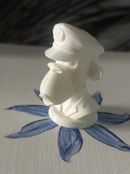urn of a white monkey figurine with a blue flower design, placed on a white surface against a black background.