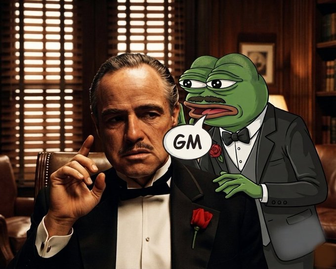 A meme image shows a scene from 'The Godfather' with Marlon Brando, accompanied by a cartoon Pepe the Frog character in a tuxedo saying 'GM' (good morning) in a speech bubble.