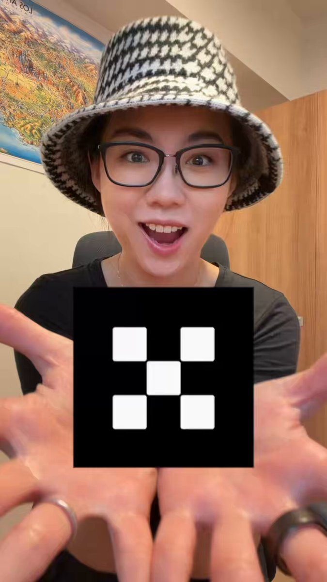 The image features a woman wearing glasses, a black hat, and holding up her hands with a square symbol or code written on them. The caption of the image reads "Time to post more bangers with @okx Auntie is onboarded." This suggests that the woman might be sharing something related to the "@okx" account or following someone's posts on social media platforms, possibly discussing or reviewing content posted by the account.