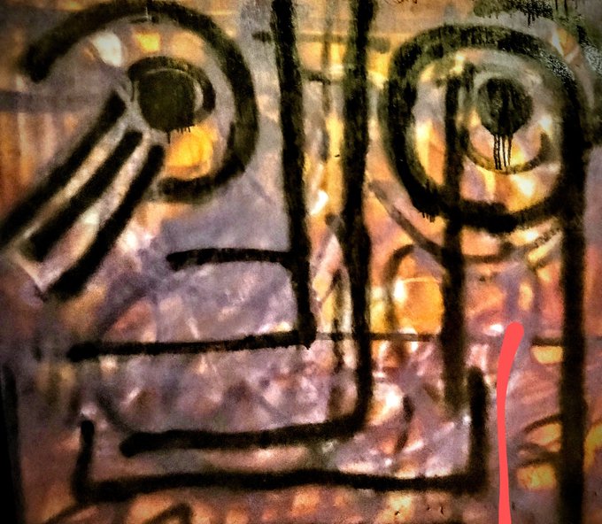 An abstract painting or textured surface features black lines over warm orange, yellow, and purple tones.