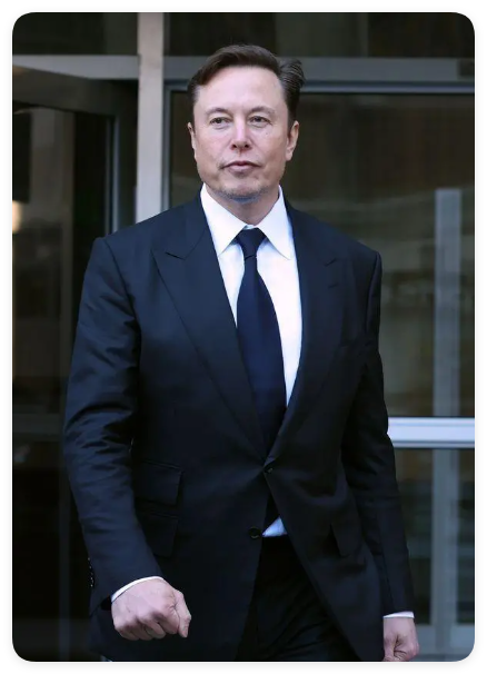 A portrait of Elon Musk, CEO of Tesla and SpaceX, wearing a dark suit and tie while walking in front of a modern glass building.