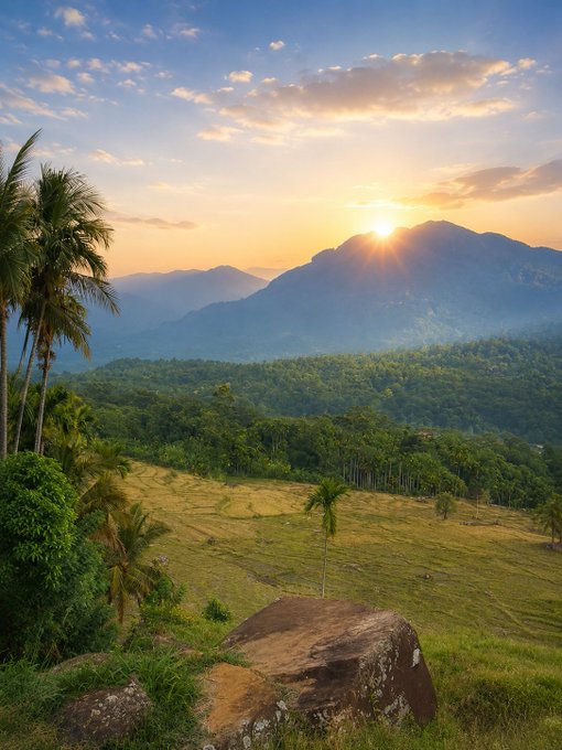 The image shows a beautiful sunset over a lush green valley, with mountains visible in the background. The sun is setting behind the mountains, casting a warm glow across the scene. In the foreground, there are palm trees that add to the tropical ambiance of the landscape. The photo appears to be taken from an elevated position, possibly on top of a hill or mountain, providing a stunning view of the valley below and the sky above it.

The post in the image is about the importance of staying grounded during challenging times. It encourages viewers to remember why they started their journey and reminds them that life has its ups and downs, just like the changing seasons. The sunset serves as a metaphor for the passage of time and the natural beauty that can be found even after enduring difficult moments.