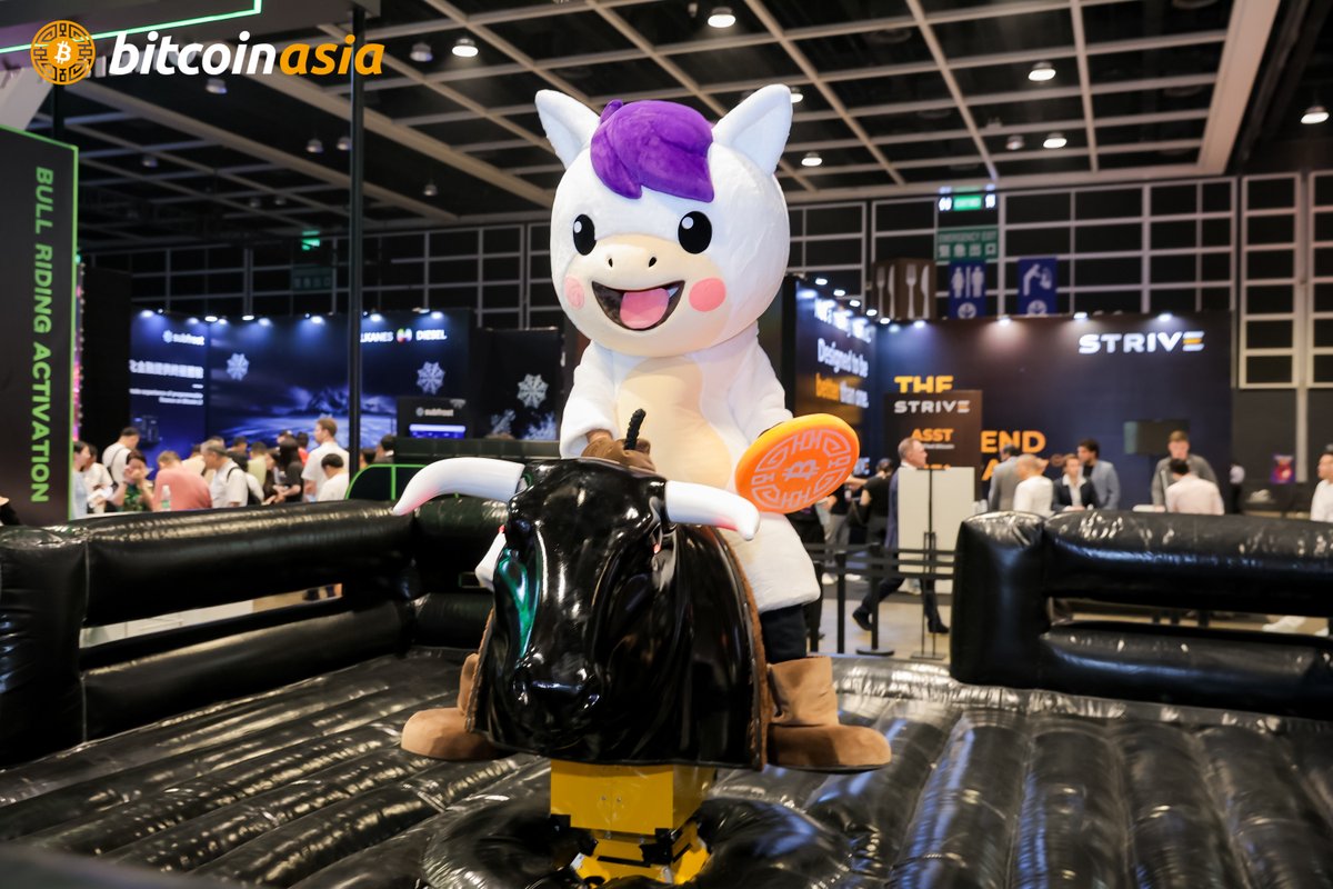 The image, watermarked with the Bitcoin Asia logo, shows a person in a horse mascot costume with a purple mane—presumably "BAO BAO"—riding atop a mechanical bull as part of a "Bull Riding Activation" event at the Bitcoin Asia conference.