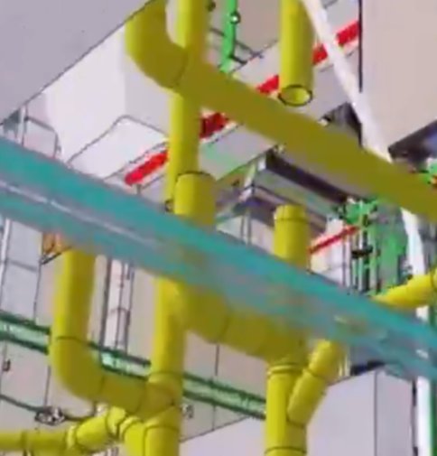 A view of an industrial facility showing a complex network of color-coded pipes—primarily yellow, with green, red, and teal/blue lines—running along the ceiling and walls, suggesting a utility, mechanical, or processing room. The image's color-coded piping layout visually echoes the concept of "BIP-110-coded architectural plans," where such color schemes are commonly used to differentiate systems in technical drawings.