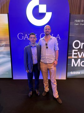 Two men pose together in front of a "GATE.IO" branded backdrop at the Token2049 Singapore event, with a "Gate.io" logo and partial text "Hold A...Cash Cry...On...Ev...Mo" visible on the sides. The image captures co-founder Chris (@theflyinghutch) alongside Han (@Han_Gate), founder and CEO of @Gate, reflecting the post's mention of their discussion on driving USDT adoption on Bitcoin.