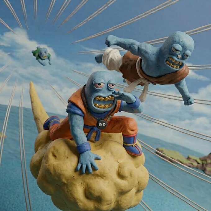 A photograph of a Dragon Ball figurine diorama depicting two blue-skinned characters (one on a Flying Nimbus cloud) flying with speed lines against a sky and ocean backdrop, characteristic of the 'Dragon Ball Z' anime aesthetic.