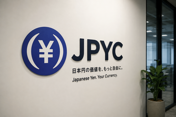 A JPYC (Japanese Yen) logo sign on a white wall reading 'Japanese Yen. Your Currency.' with Japanese text above the English translation.