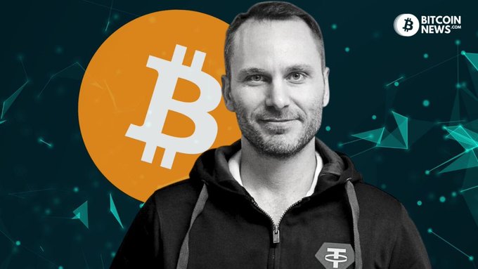 Bitcoin News graphic featuring a man in a black hoodie with a T (Tao) emblem, standing in front of an orange Bitcoin logo on a teal blockchain network background.