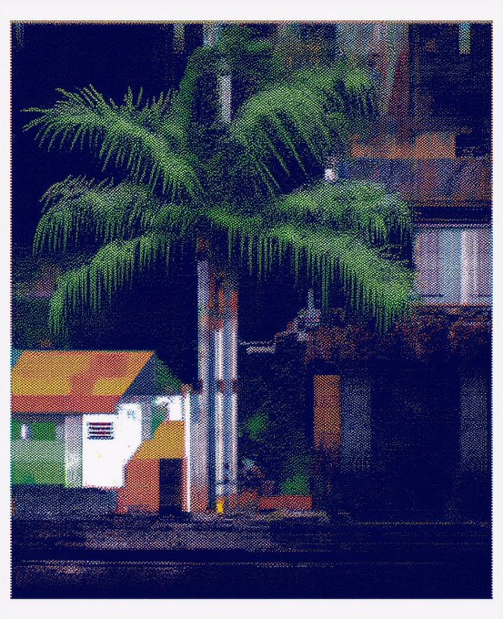 A pixelated or cross-stitch style artwork depicting a large green palm tree in front of a building with colorful orange and yellow elements.