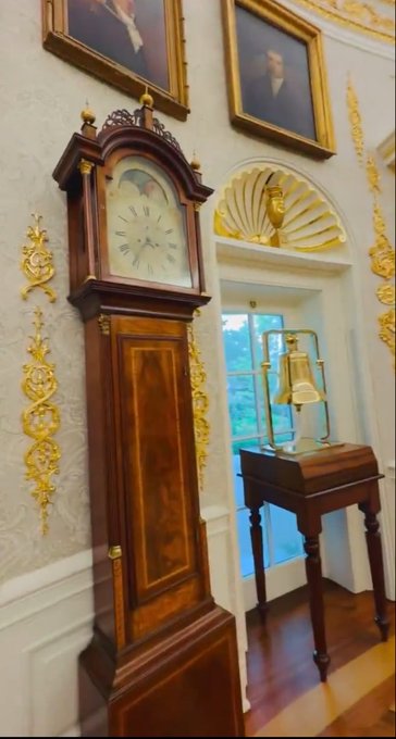 A grandfather clock with a face depicting what appears to be a map and Roman numerals stands beside a small wooden table holding a brass bell under a golden shell-shaped alcove, with framed portraits hanging on the ornately decorated walls above. The post's "OVAL OFFICE PROBABLY NOTHING" caption appears to mock conspiracy theories about subtle changes in the White House's décor, though no overt anomalies are visible in this elegant interior shot.