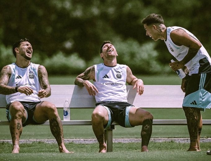 Three soccer players wearing white training bibs with "Google Pixel" sponsorship sit on a bench laughing during practice, sharing a lighthearted moment on the pitch.

The image shows Argentina national team players sharing a joyful moment during training, tying into the post about a bettor who wagered on Argentina to win the World Cup and is now one game away from a massive payout.