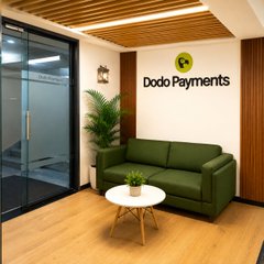 A small, minimalist waiting area with a green sofa and a small coffee table features a prominent "Dodo Payments" logo on the wall, suggesting the company may be growing, as hinted by the post's mention of 11 million views.