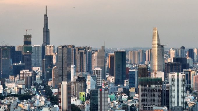 A panoramic skyline view of a city featuring modern skyscrapers including the Bitexco Financial Tower with its helipad.
