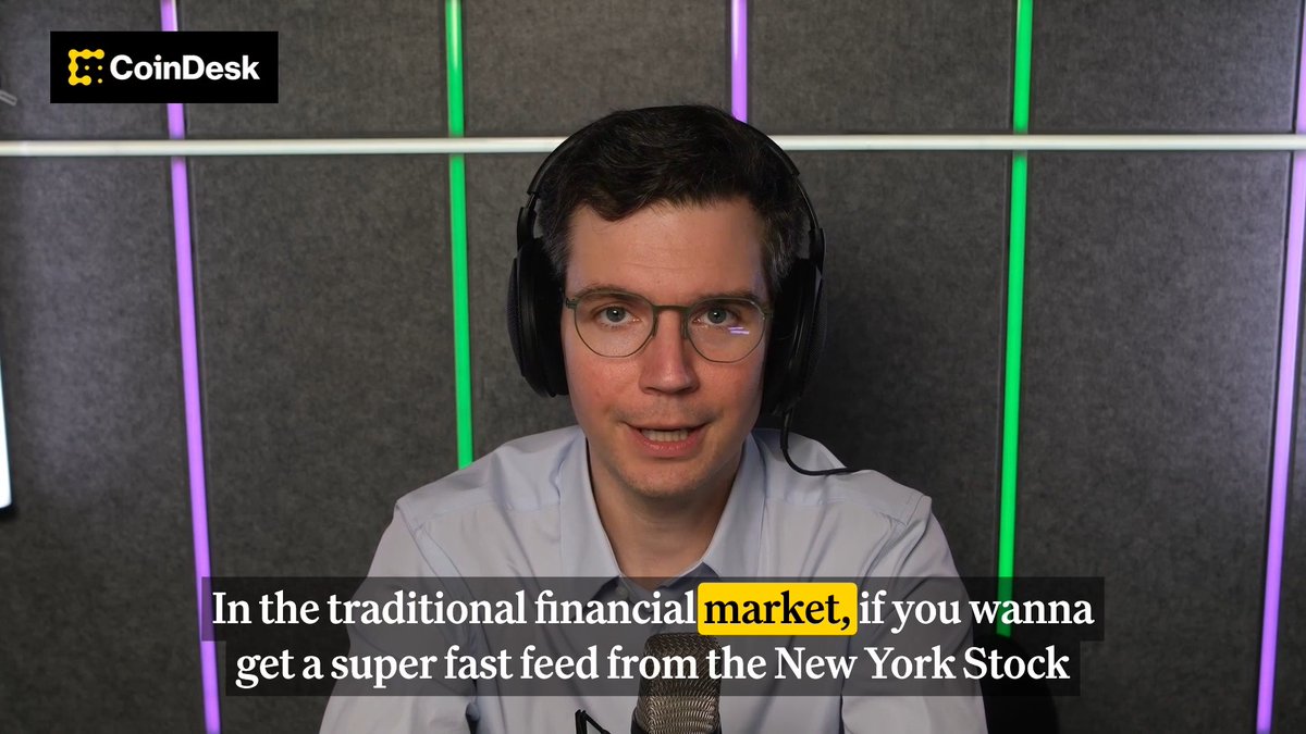 Austin Federa of DoubleZero, wearing headphones and a light blue shirt, discusses how DoubleZero Edge democratizes access to low-latency market data feeds that were once exclusive to Wall Street firms, in a CoinDesk interview sponsored by realfi_co. The on-screen text reads: "In the traditional financial market, if you wanna get a super fast feed from the New York Stock..."