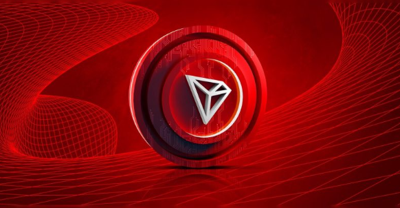 A digital rendering featuring a silver/gold cryptocurrency coin with a diamond-shaped logo set against a red background with flowing wireframe patterns.