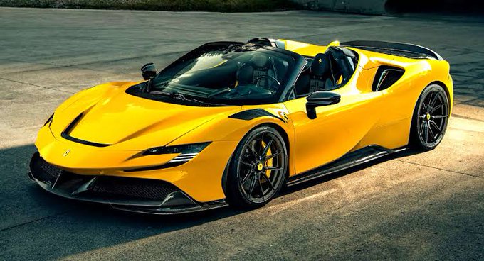 The image features a yellow sports car with black rims parked on a concrete surface, possibly an airport tarmac or parking lot. The car's design suggests that it could be a convertible, as indicated by its open top. The background of the image is blurred and out of focus, drawing attention to the car in the foreground.