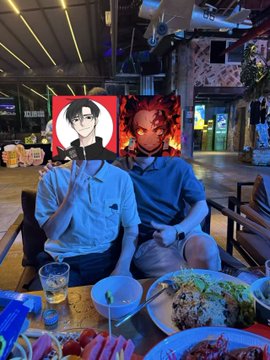 Two friends sit at a restaurant table with beers and food, watching a World Cup match on a large screen with an anime-style character overlay, joining the OKX World Cup event gathering with massages and drinks.