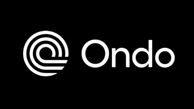 The image displays the Ondo Finance logo in white text against a black background, featuring the brand name "Ondo" next to its distinctive circular emblem. The logo relates to the post by visually identifying Ondo Finance as the company partnering with Japan's SBI Group to bring Japanese stocks onto the blockchain.