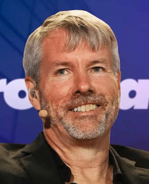A man with short gray hair and a beard smiles at what appears to be a speaking event, wearing an earpiece and dark jacket against a blue branded backdrop.