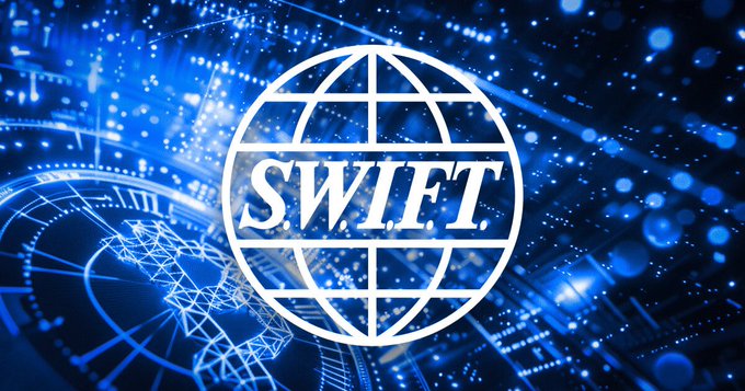 The image features a logo for SWIFT, which stands out against a blue background with white lines. The text "SWIFT" is written in white letters above the logo. Below the logo, there are descriptions of SWIFT's role in modernizing global payments and its partnership with major banks to facilitate crypto-enabled payment rails.