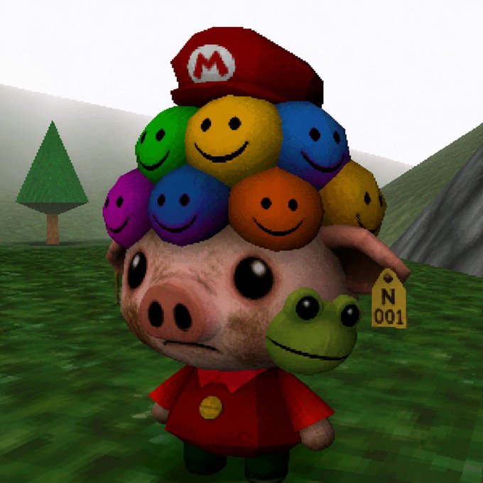 A 3D rendered character has a pig's head wearing a Mario hat made of colorful smiley face spheres, with a small frog attached to its cheek.