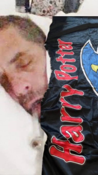 A poorly cropped image showing a man's bearded face with a wound next to a dark flag that reads 'Trump 202' in red letters with a partial eagle logo.