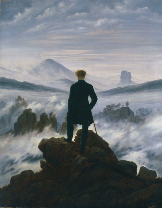 The famous Romantic painting 'Wanderer above the Sea of Fog' by Caspar David Friedrich, showing a man in a dark coat standing on a rocky peak overlooking a misty mountain landscape.