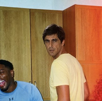 A man in a yellow shirt gives a skeptical side-eye glance while another man in a blue shirt laughs beside him, with a "$ANSEM" logo visible on the blue shirt. The image humorously captures the judgmental reaction of skeptics doubting a bold endorsement of the $ANSEM coin as a path to financial freedom.