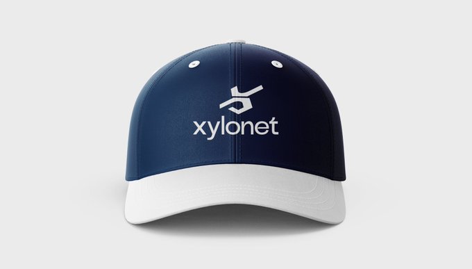 A navy blue and white baseball cap displaying the 'xylonet' logo (a stylized hand symbol above the brand name) on a plain white background.