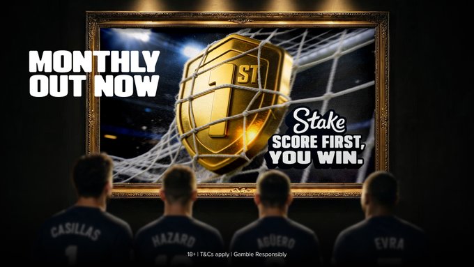 The image shows four people wearing soccer jerseys with the names "Casillas," "Hazard," "Neymar," and "Evra" on the back, standing with their backs to the viewer as they look at a large ornate painting of a golden "Stake" logo inside a soccer goal net. Text overlays read "MONTHLY OUT NOW" and "Stake SCORE FIRST, YOU WIN," with a footer noting "18+ | T&Cs apply | Gamble Responsibly," directly supporting the post's announcement of the new Monthly issue and the "Score First, You Win" promotion.