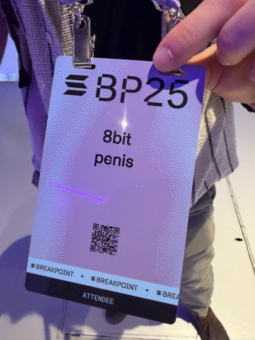 The image shows a person holding up an electronic device with a white label that says "BPC25 8bit penis" printed on it, along with some text. The background of the image appears to be a dark room or a dimly lit area. There is also a small amount of text visible in the image, which reads: "this encounter !" and "@SolanaEvents". This suggests that there might have been an event at Solana recently, possibly related to cryptocurrency or blockchain technology. The person holding up the device could be sharing information about this event with others or simply showing off their electronic device.