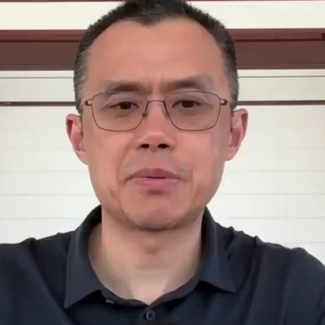 The image features a man wearing glasses, standing against a white wall with a window behind him. The man appears to be looking directly at the camera, possibly posing for a photo or participating in an interview. The caption of the image reads "THIS IS AMAZING BINANCE FOUNDER CZ MADE A BOLD PREDICTION ABOUT THE FUTURE OF AI AND CRYPTOCURRENCY." This statement suggests that there is a connection between the man's appearance and the content of the image, possibly related to an article or news piece about the intersection of technology, finance, and human behavior.