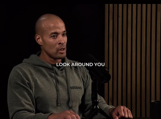 A bald man wearing a gray 'GOGOINS' hoodie speaks in what appears to be a podcast or interview setting. The subtitle reads 'LOOK AROUND YOU'.