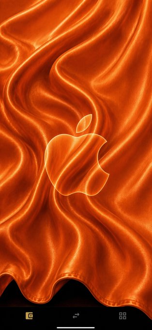 An Apple iPhone wallpaper featuring the iconic Apple logo embossed on a flowing orange satin fabric background.