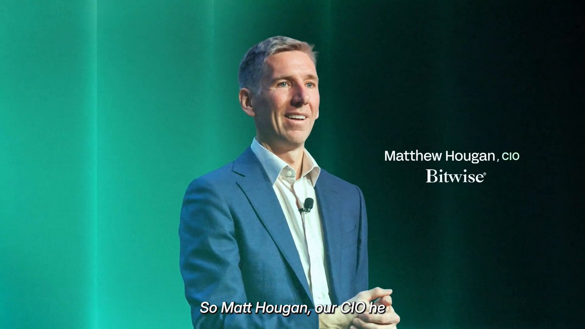 The image features a man wearing a suit standing on stage with his hands at his sides, giving him an air of confidence as he speaks into a microphone. The background behind him has a green color that contrasts with the white text displayed below him. Below the main subject, there is some additional information about DeFi vaults and their services, which includes details such as the time it takes to complete transactions and the types of assets they offer.