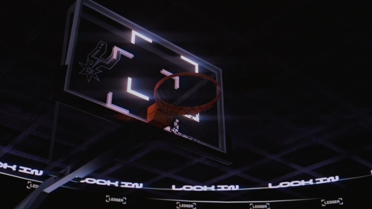 A nighttime basketball hoop adorned with the San Antonio Spurs logo and "Ledger" branding, promoting the Ledger Nano x Spurs event at Token2049 Singapore tomorrow.