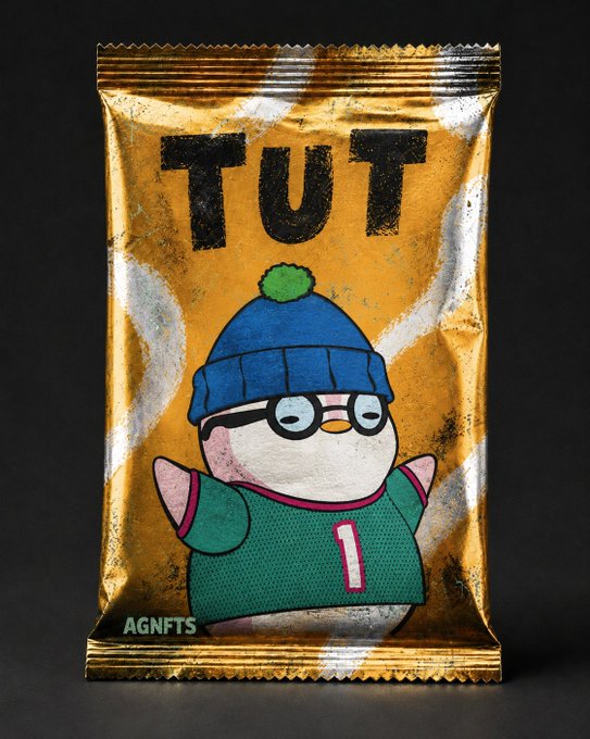 A gold foil trading card pack labeled 'TUT' features a cartoon penguin character wearing a blue beanie, glasses, and a green jersey with the number 1, with 'AGN FTS' text in the corner.